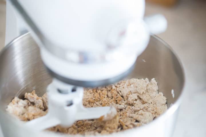 Peanut butter bars filling being mixed in a stand mixer with a paddle attachment.
