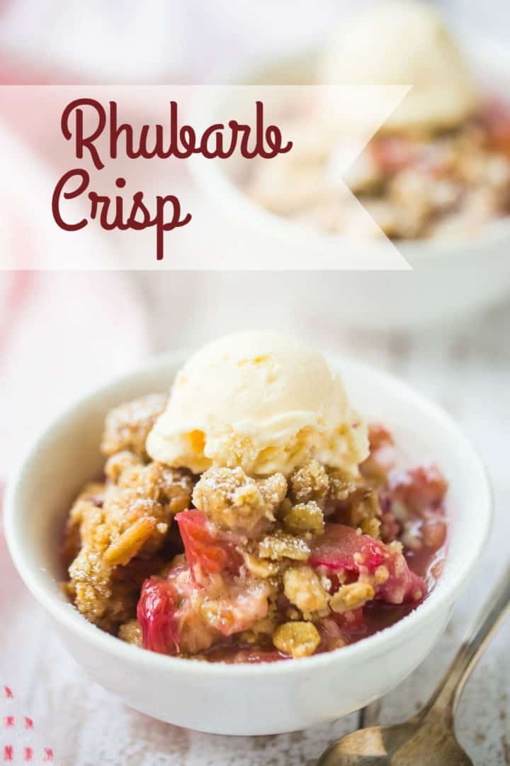 Two bowls of rhubarb crisp with vanilla ice cream on a distressed white wood background.