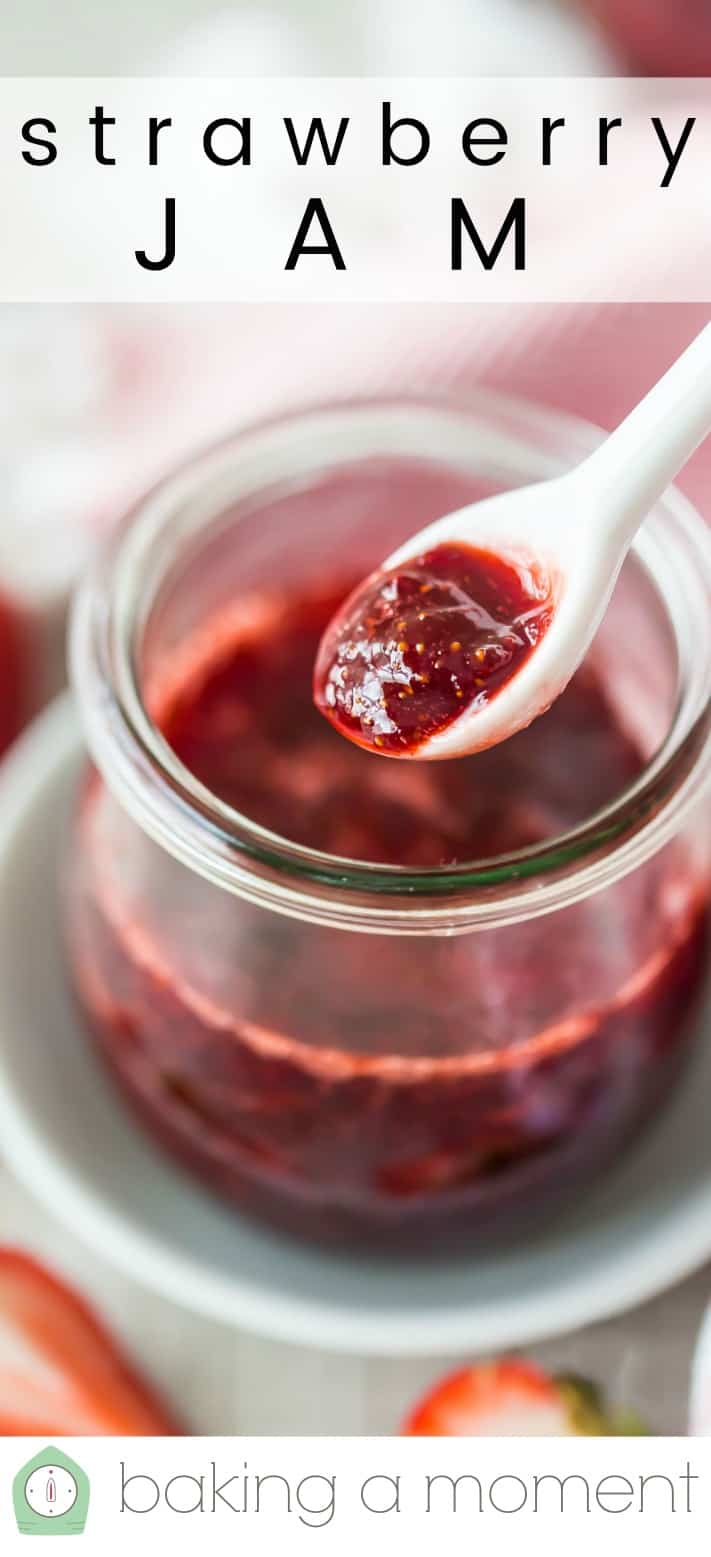 Small jar of homemade strawberry jam, with a white ceramic spoon and a text overlay reading "Strawberry Jam."