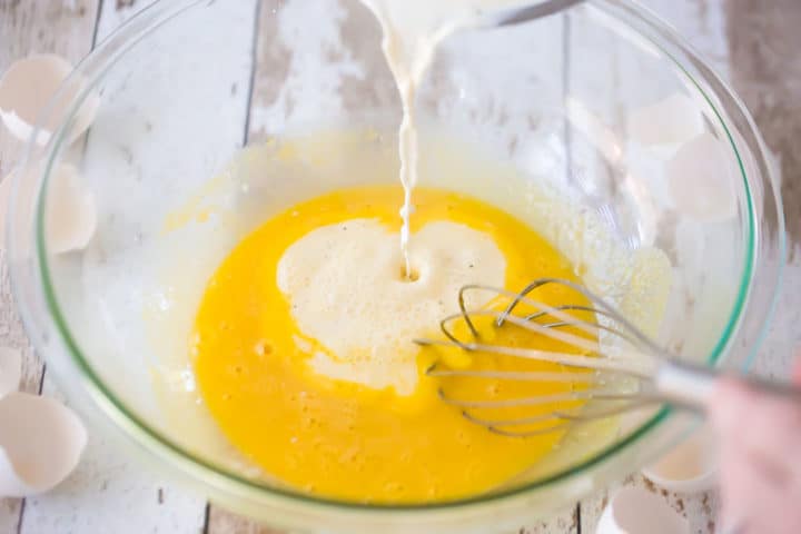Tempering eggs with hot cream.