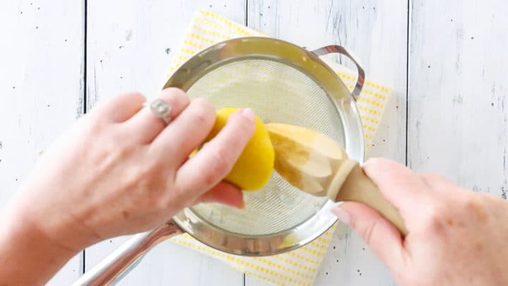 Juicing fresh lemons with a wooden reamer.
