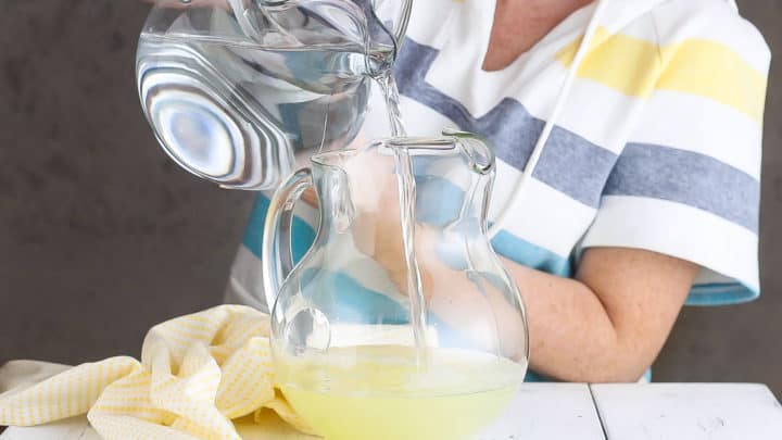Adding water to homemade lemonade.