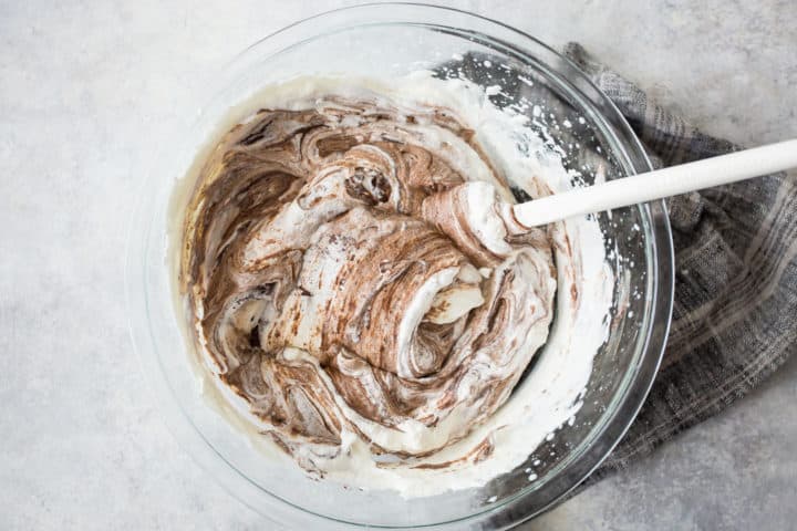 Folding chocolate into whipped cream.