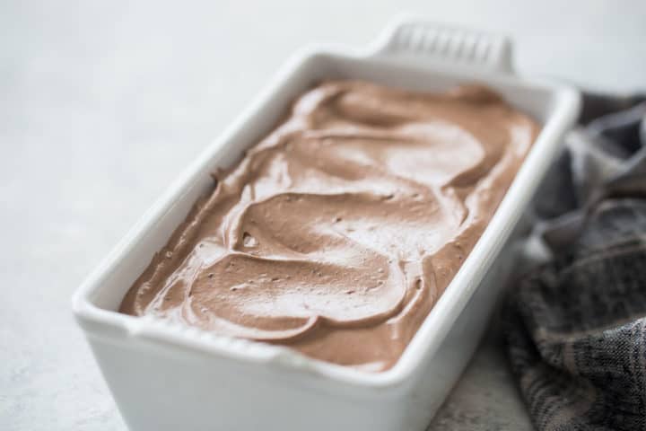 Homemade chocolate ice cream in a white ceramic loaf pan.