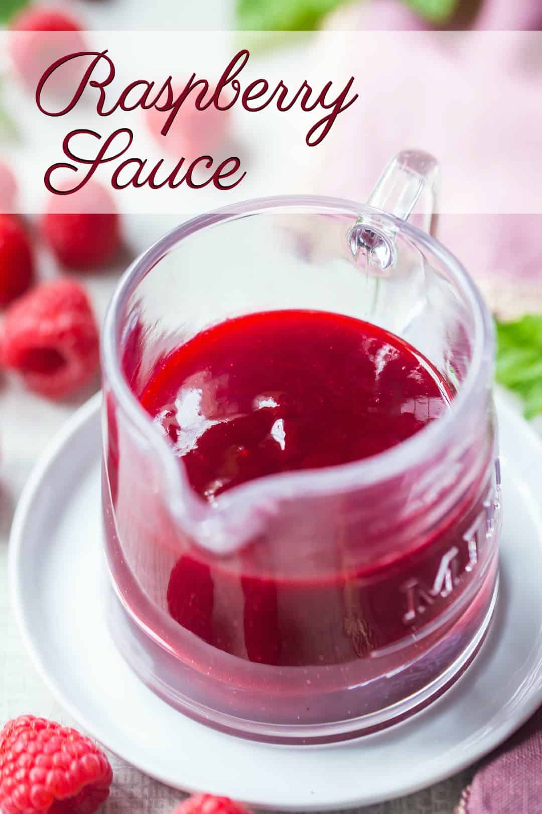 Small glass pitcher of seedless raspberry sauce, with a text overlay above that reads "Raspberry Sauce."