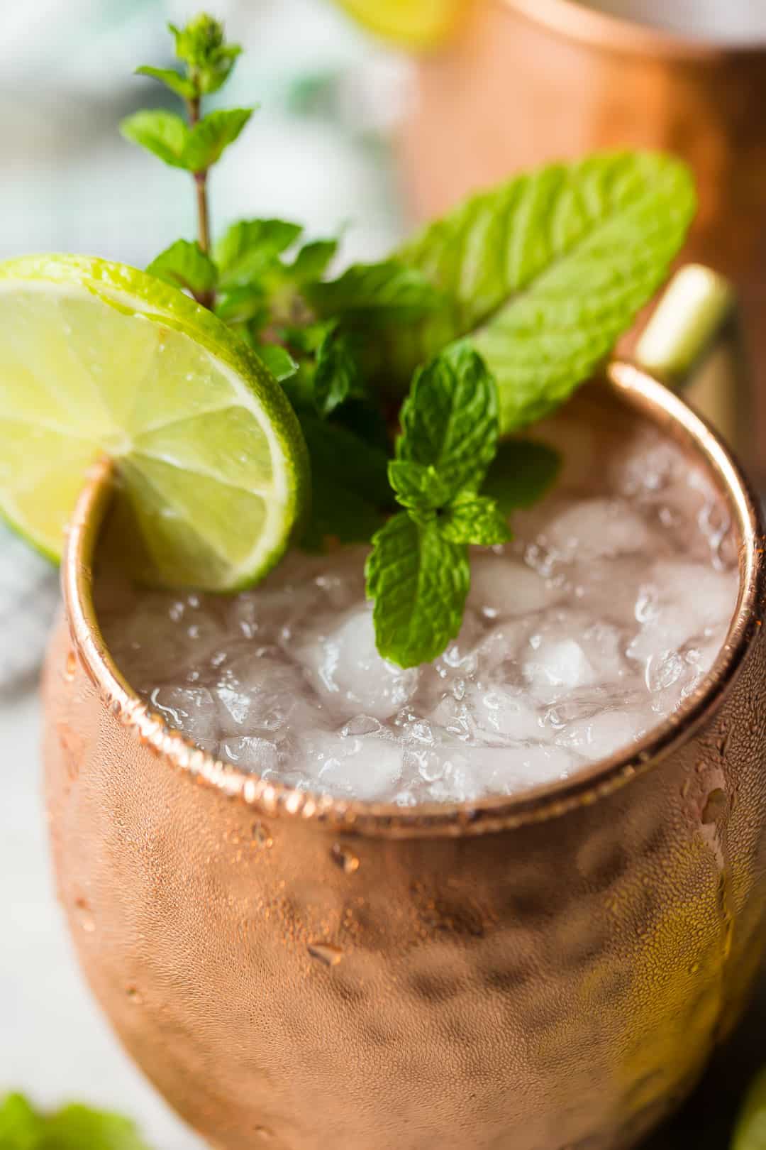 Close up image of a Moscow mule drink with crushed ice, lime juice, and fresh mint.
