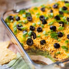 7-Layer dip in a square glass dish, with a green napkin.