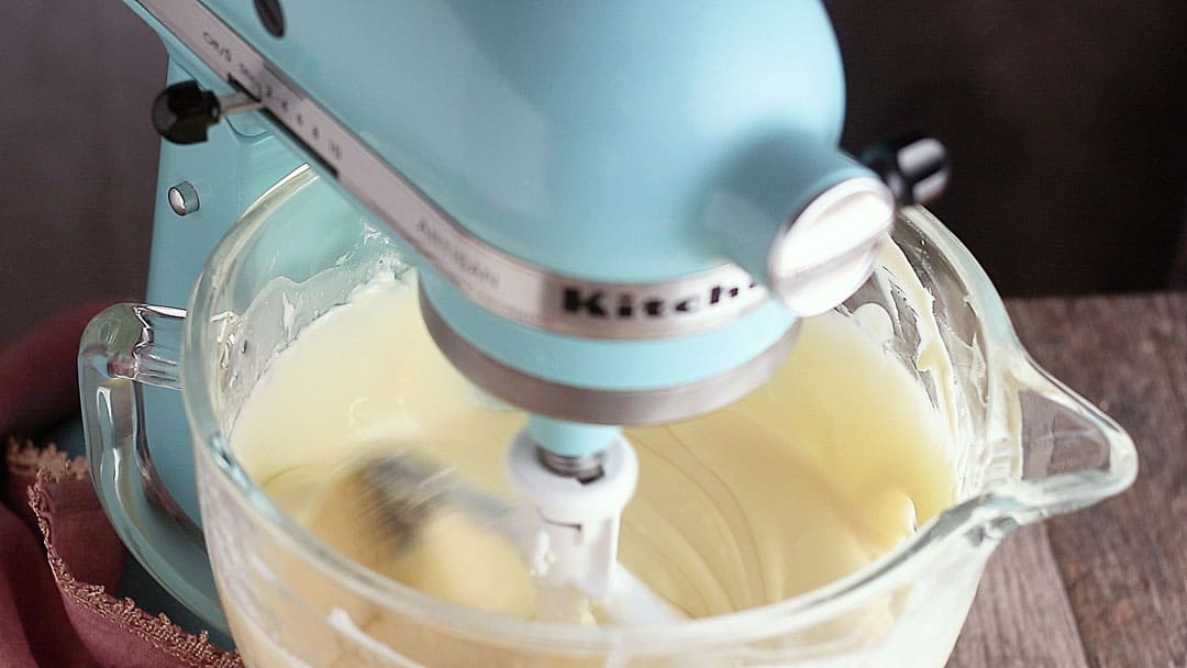 Stirring cheesecake batter in a stand mixer.