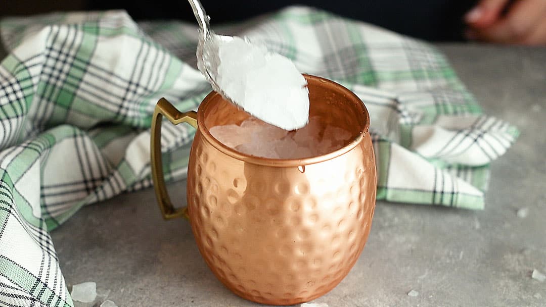 Filling a copper mug with crushed ice.