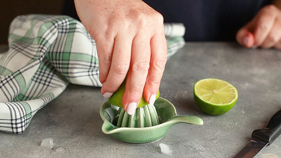 Juicing fresh limes with a small ceramic citrus reamer.