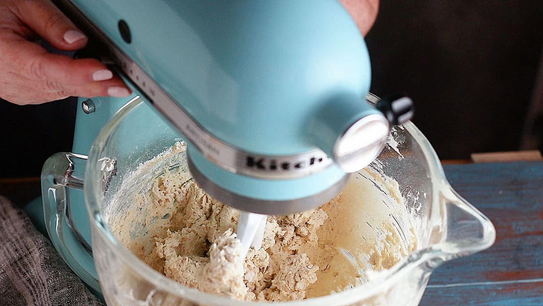 Making oatmeal cookie dough in a blue stand mixer.