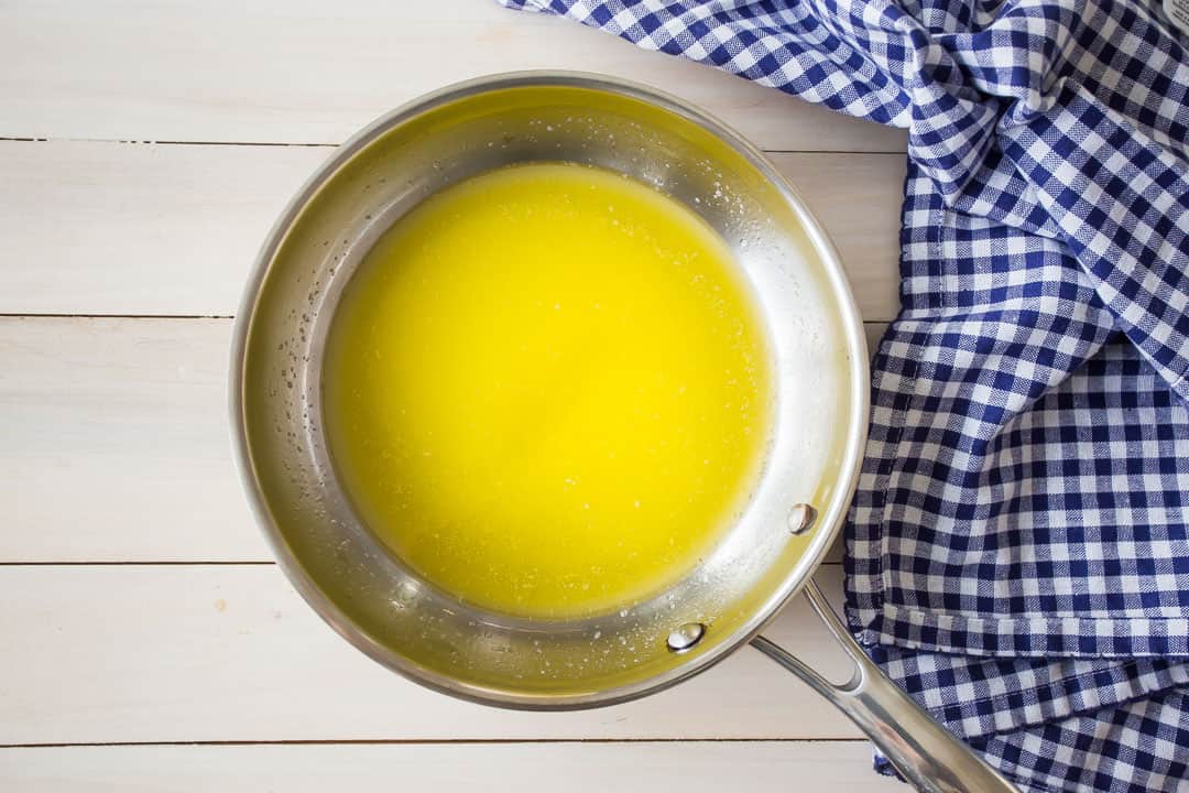Melted butter in a small stainless steel skillet.
