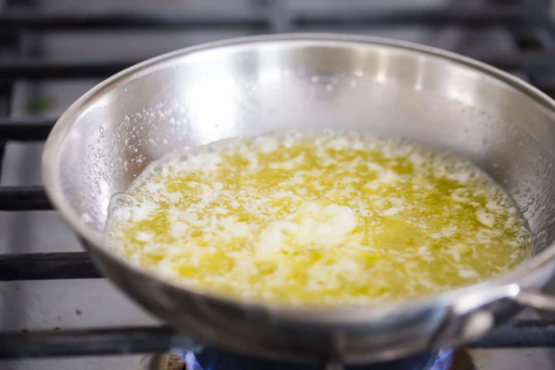 Boiling butter in a small stainless steel skillet.