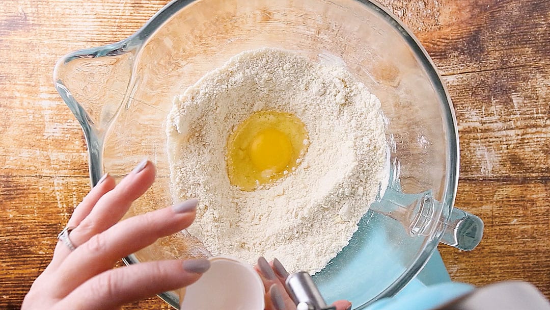 Adding egg to sour cream cake batter.