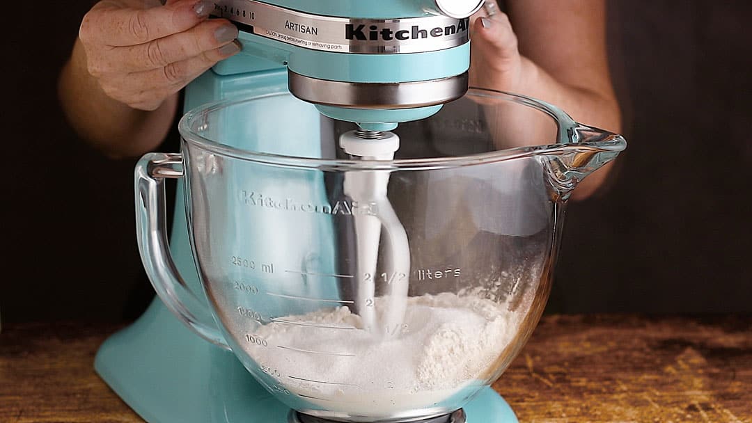 Stirring dry ingredients together in a stand mixer.
