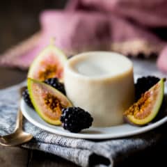 Panna Cotta on a small plate with fresh figs and blackberries.