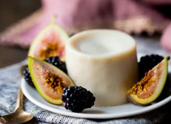 Panna Cotta on a small plate with fresh figs and blackberries.