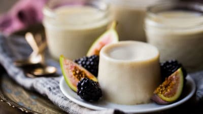 Italian panna cotta recipe with figs and blackberries, on a brass tray.
