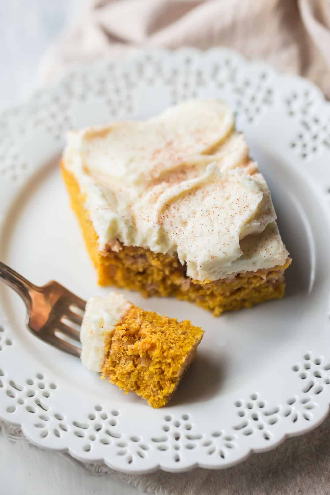 Slice of best pumpkin cake recipe on a white plate with a bite on a fork.