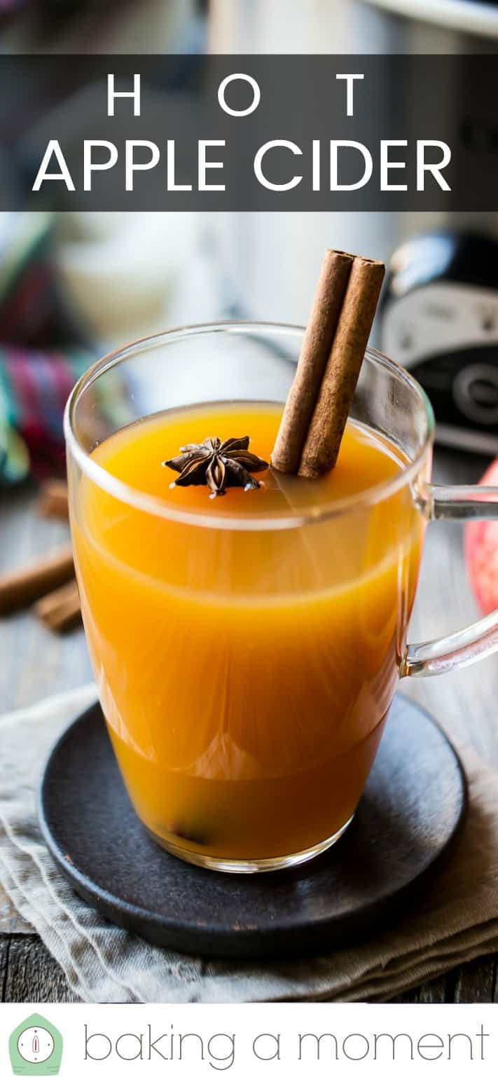 Mulled cider in a glass mug with cinnamon, citrus, and spices, with a text overlay above reading "Hot Apple Cider."