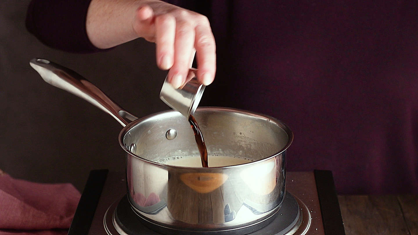 Making panna cotta: Adding vanilla extract.