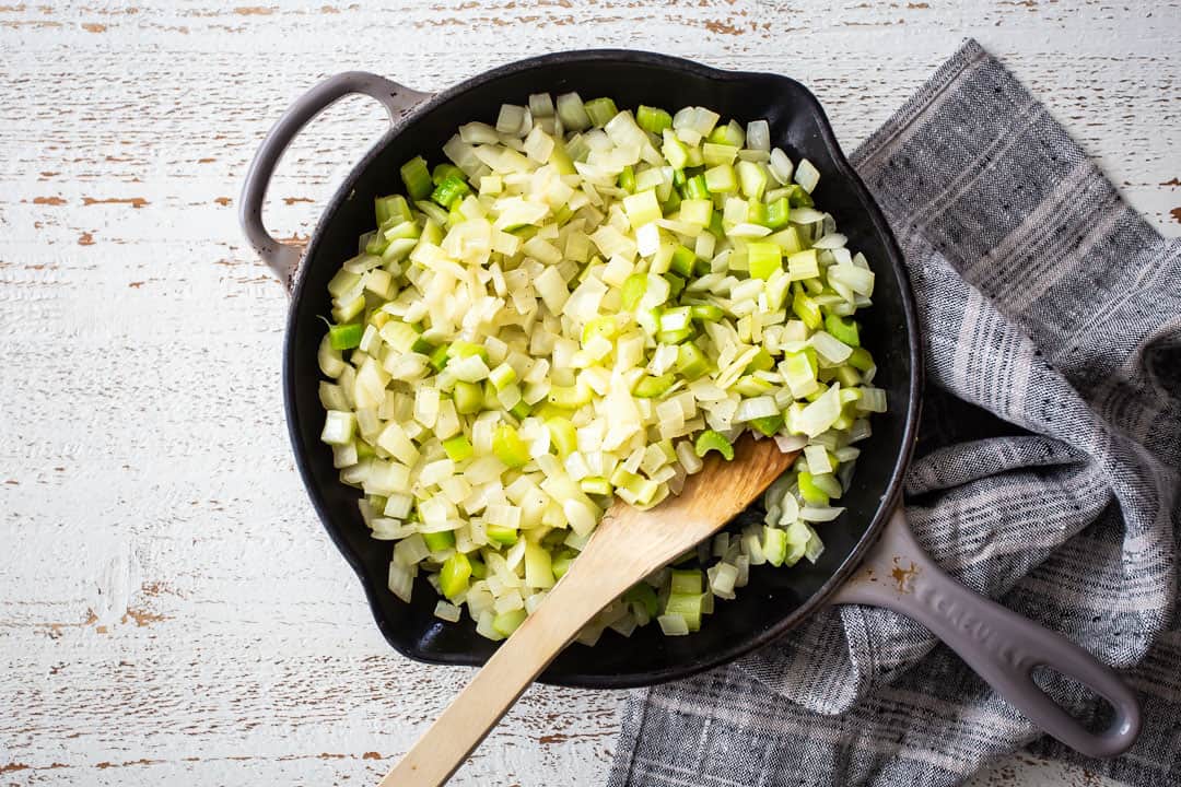 Sauteed onion and celery in a skillet, for making Thanksgiving stuffing.