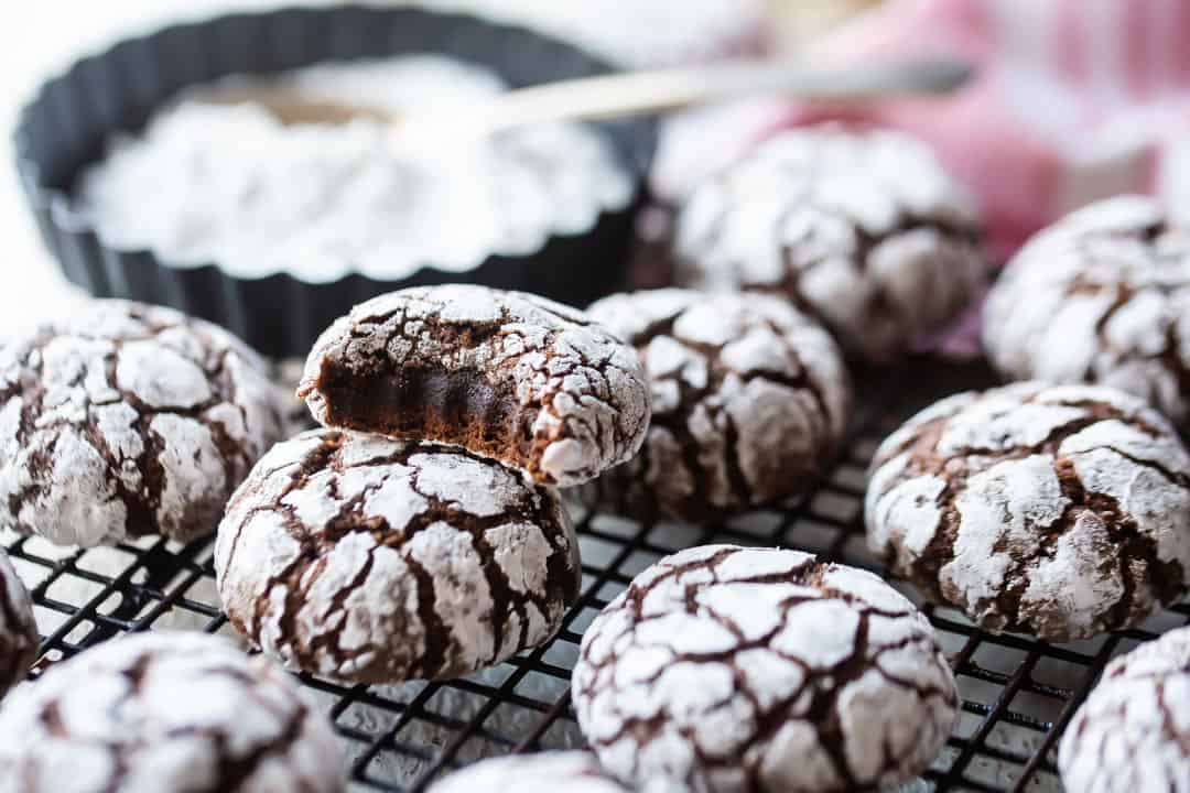 Chocolate crinkle cookies from scratch on a wire cooling rack.