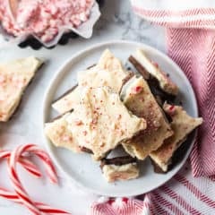 Overhead image of a stack of peppermint bark with candy canes in the background.