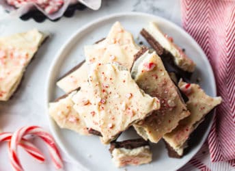 Overhead image of a stack of peppermint bark with candy canes in the background.