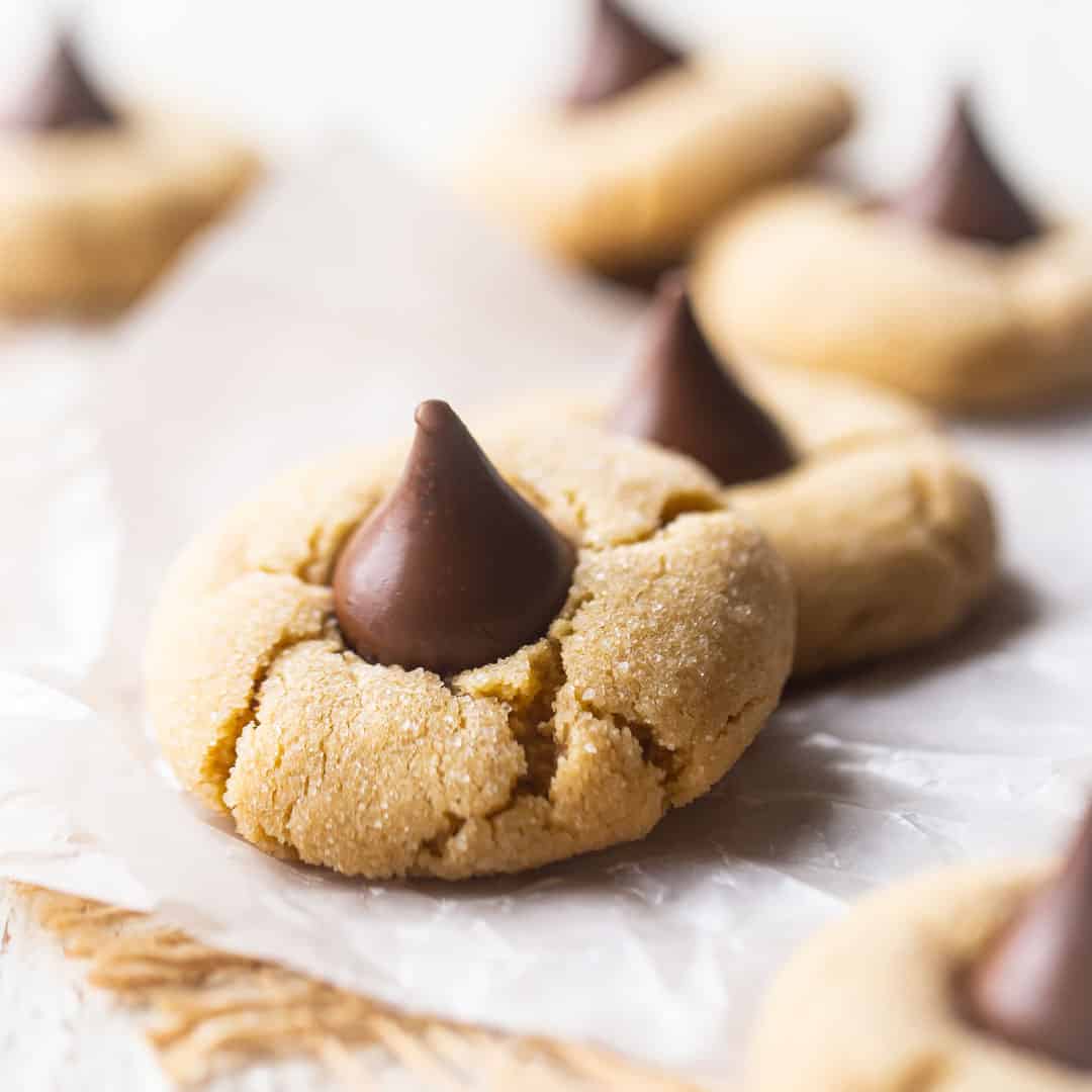 Close up image of peanut butter blossoms on a white background.
