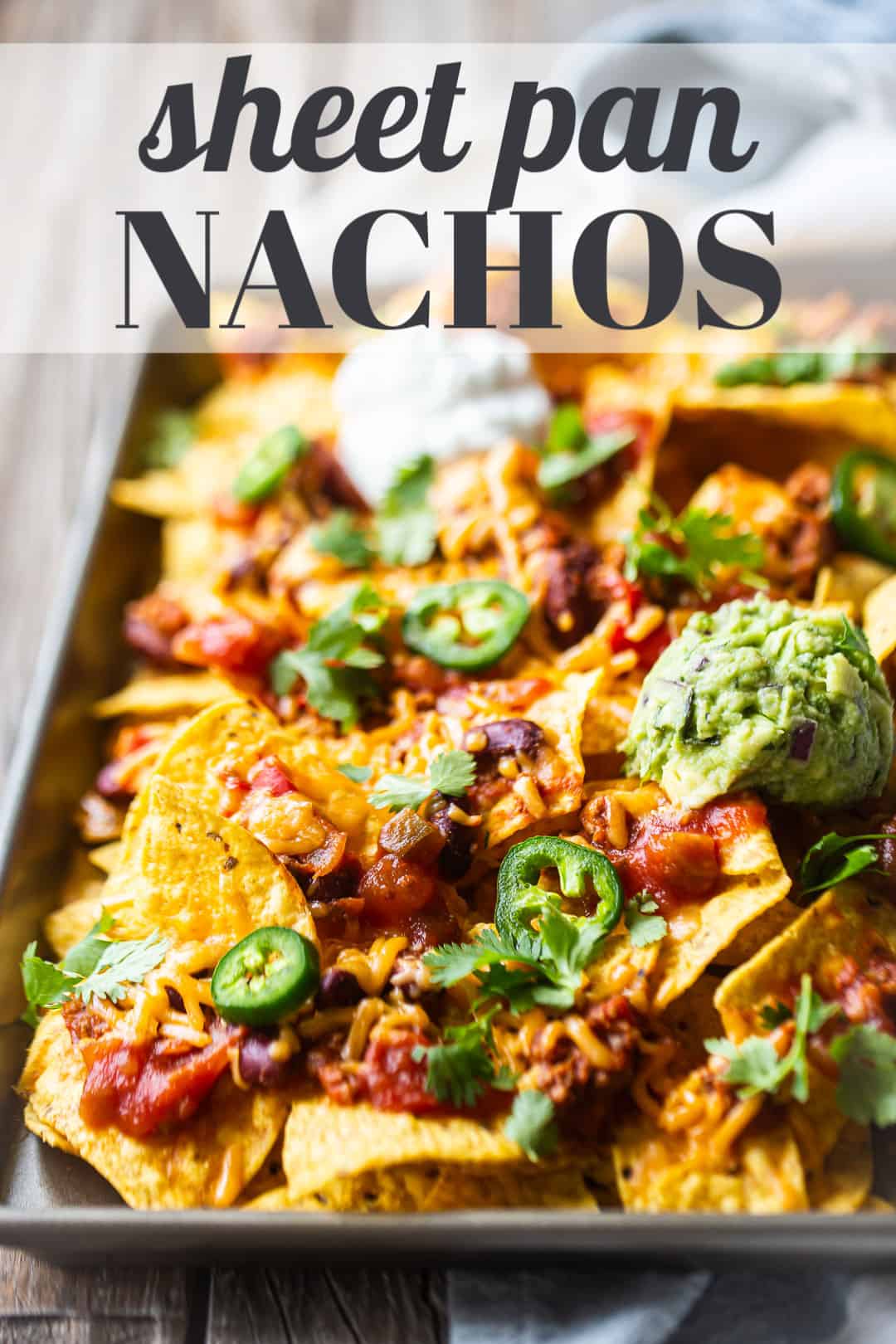 Nachos recipe, prepared on a sheet pan, with a text overlay above that reads "Sheet Pan Nachos."