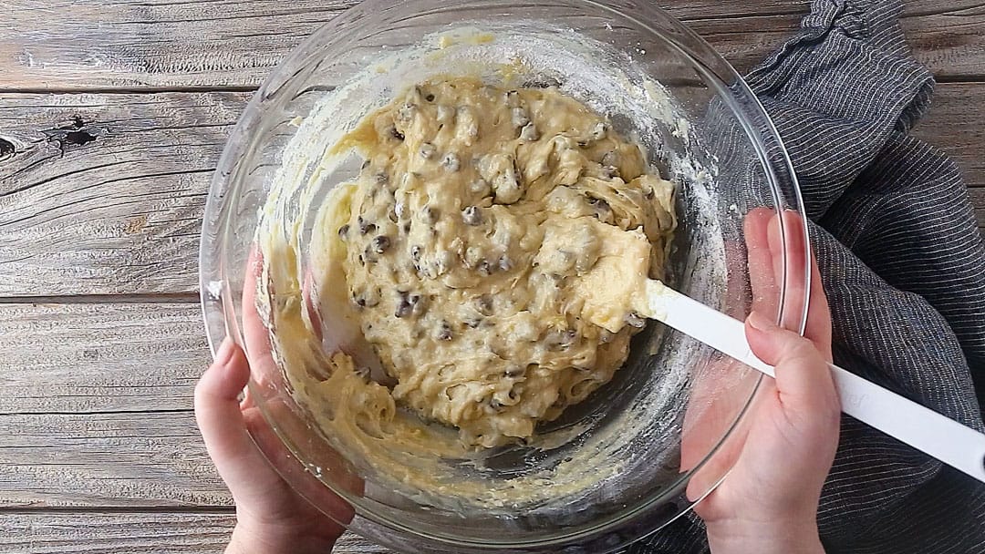 Chocolate chip banana bread batter in a glass mixing bowl.