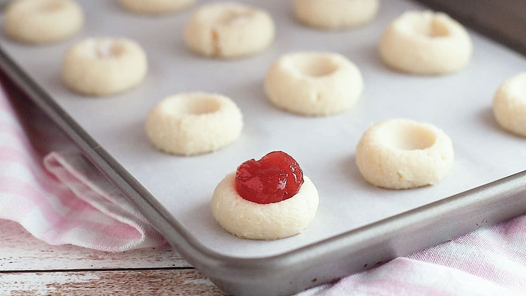Unbaked thumbprint cookies filled with jam.