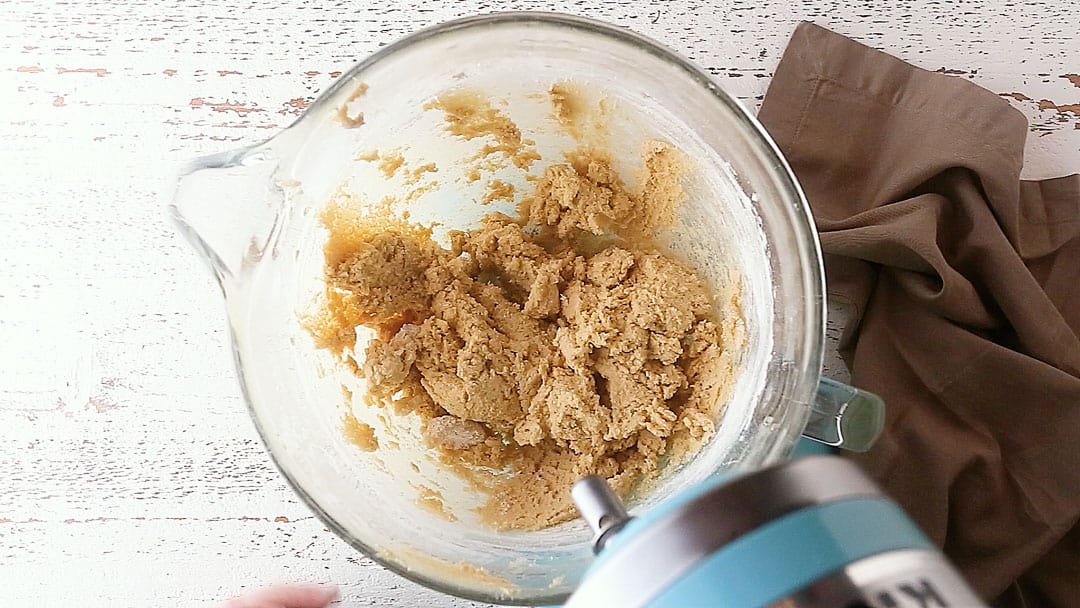 Peanut butter blossoms cookie dough in a glass mixing bowl.