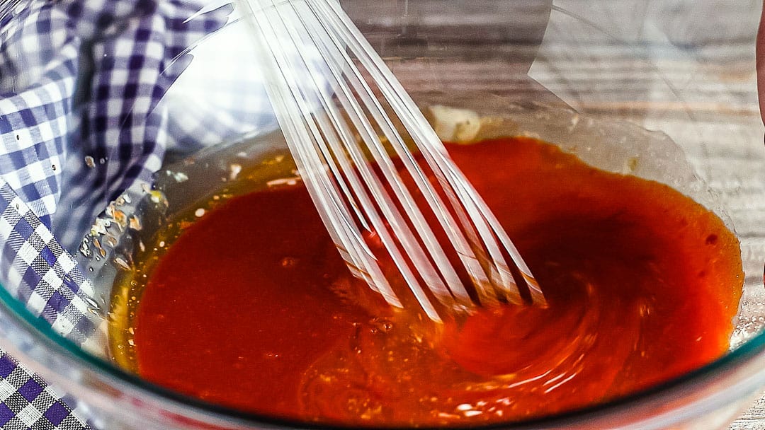 Whisking ingredients together for homemade buffalo sauce.