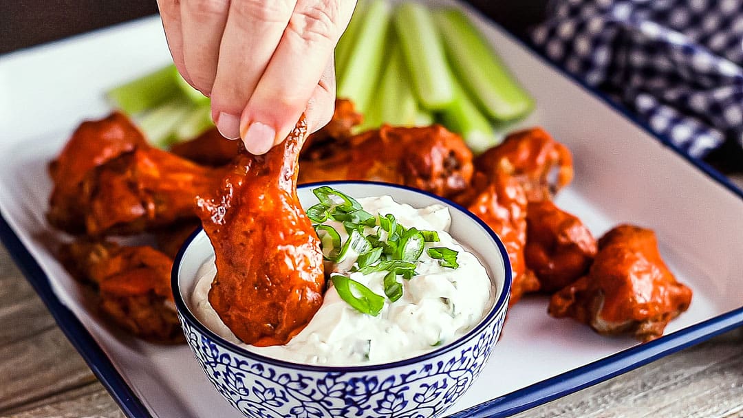 Dipping a baked buffalo wing in blue cheese dressing.