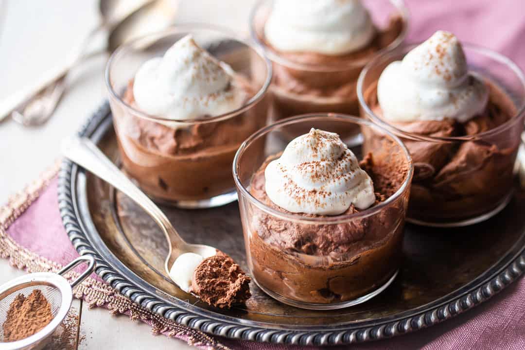 Serving quick chocolate mousse in glass cups on a silver tray with a pink linen napkin.