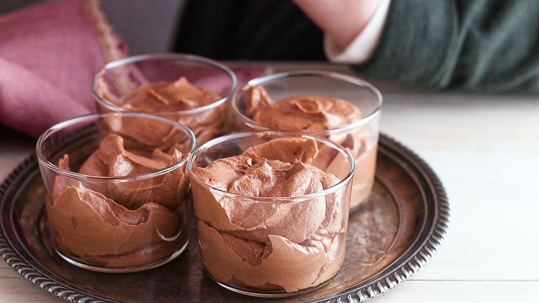 Transferring chocolate mousse into individual serving dishes.