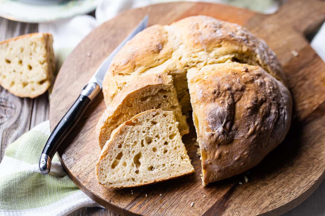 Irish soda bread recipe from Ireland, served on a wooden board with a black-handled knife.