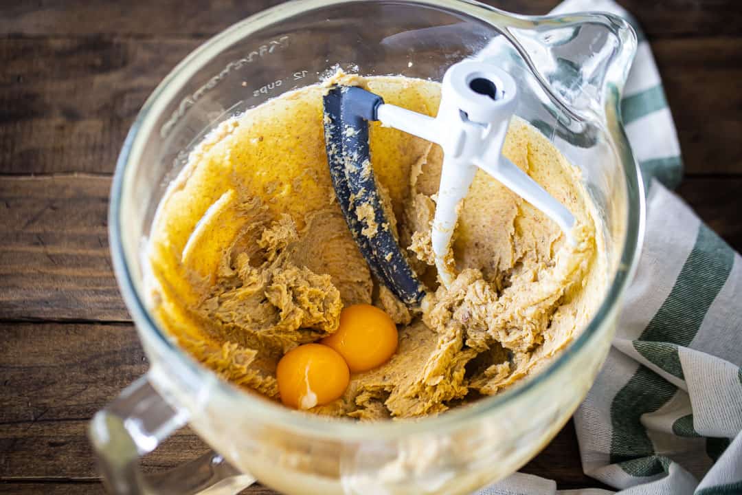 Adding egg yolks to butter and brown sugar mixture.