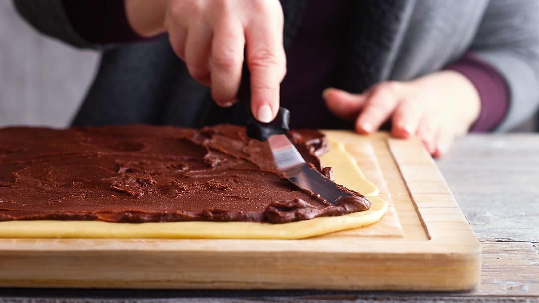 Spreading chocolate on babka dough with a small offset spatula.