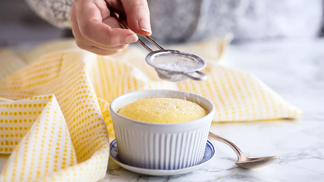Dusting lemon pudding cake with powdered sugar.