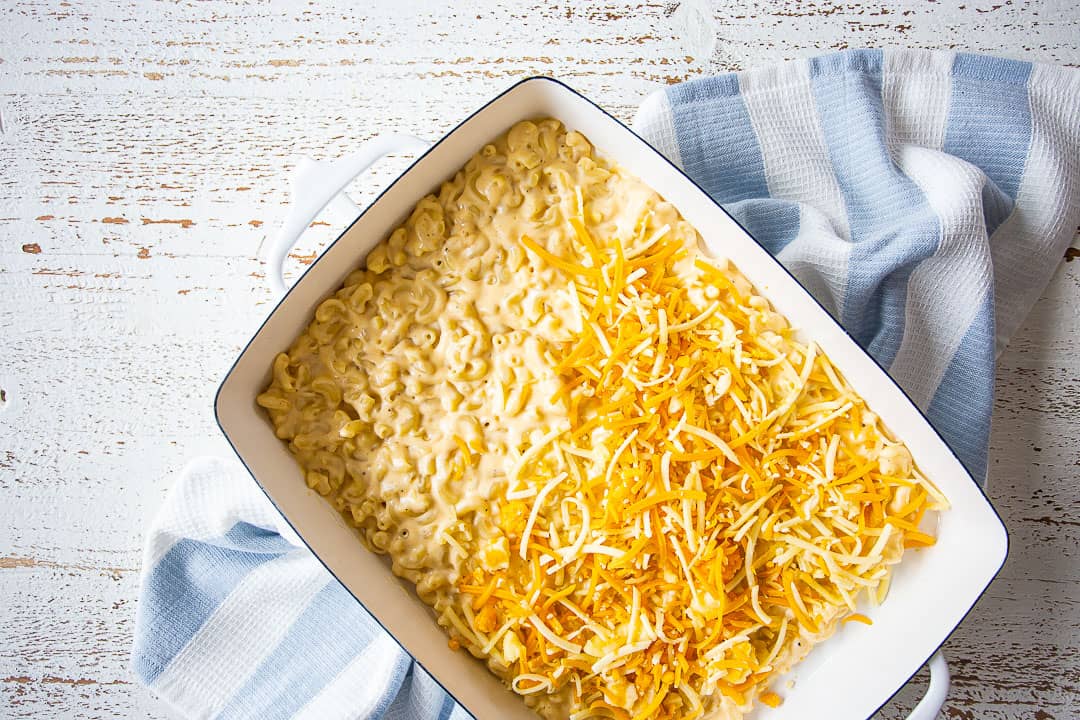 Layering shredded cheese and macaroni in a baking dish.