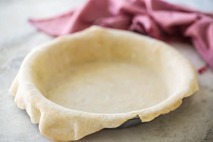 Unbaked pie crust, made, rolled out, and draped into a pie dish.