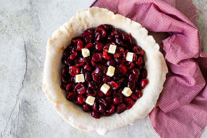 Unbaked cherry pie dotted with cold butter.