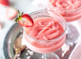 Frosé in stem glasses with strawberry garnish.