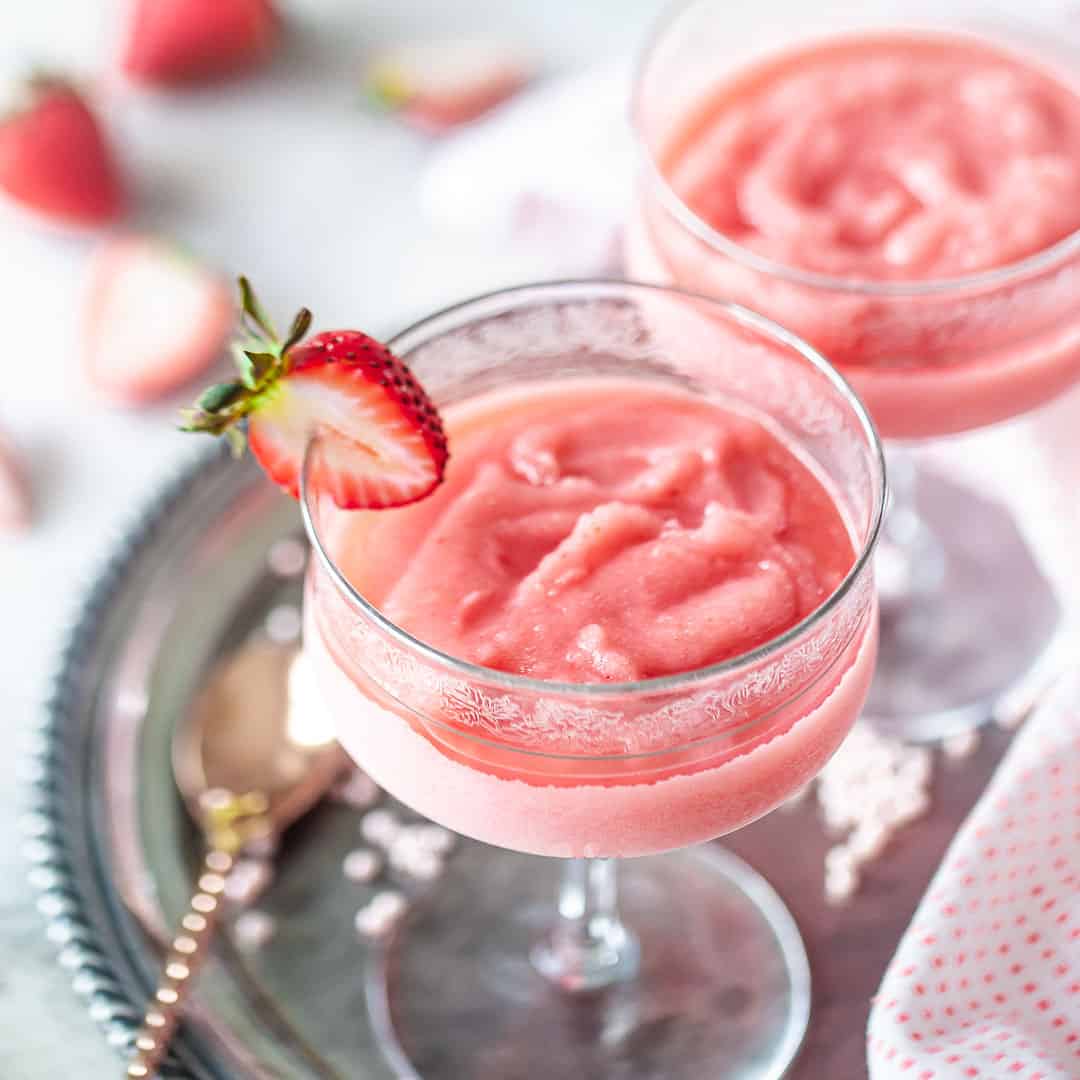 Frosé in stem glasses with strawberry garnish.