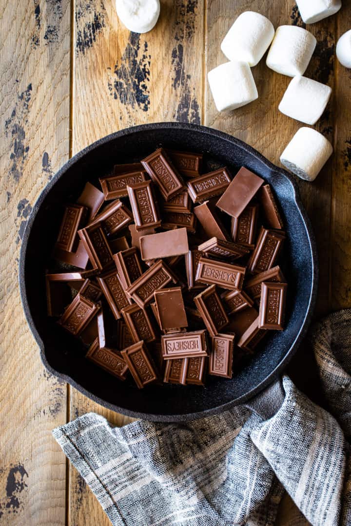 Milk chocolate bars, broken into small pieces and scattered in the bottom of an iron skillet.