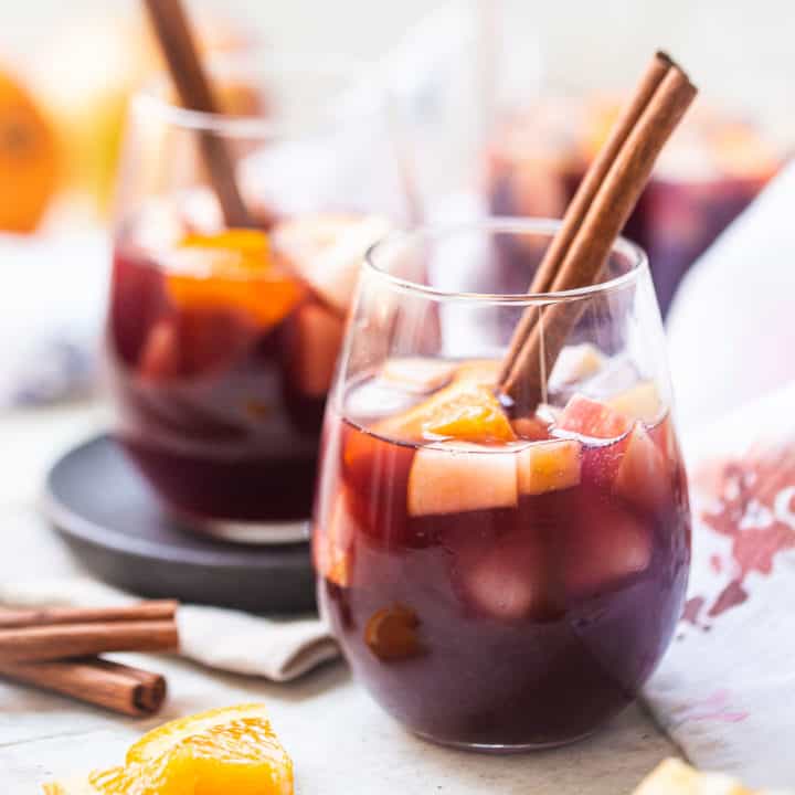 Sangria in a stemless wine glass with a cinnamon stick.