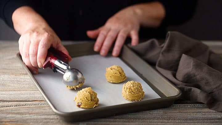 Scooping butter pecan cookie dough onto baking sheets.